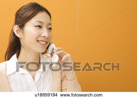 Young woman talking over mobile phone View Large Photo Image Picture - Young woman talking over mobile phone. Fotosearch