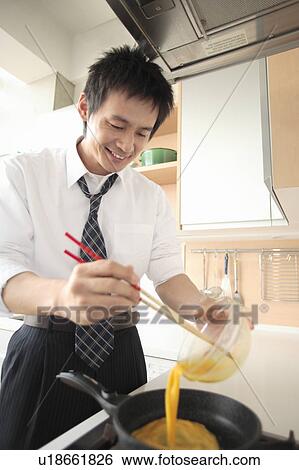 Businessman cooking in kitchen View Large Photo Image Stock Photograph - Businessman cooking in kitchen. Fotosearch