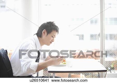 Stock Image - Businessman having breakfast. Fotosearch