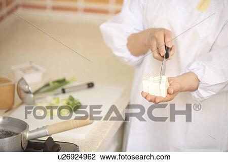 Stock Image - Human Hand cooking miso soup. Fotosearch