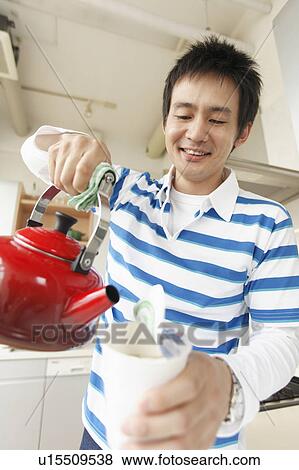 Mid adult man cooking instant noodle View Large Photo Image Stock Photo - Mid adult man cooking instant noodle. Fotosearch