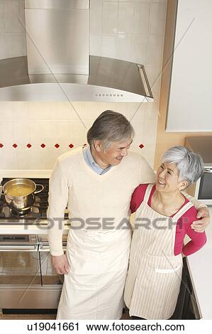 Senior couple standing in kitchen View Large Photo Image Stock Image - Senior couple standing in kitchen. Fotosearch