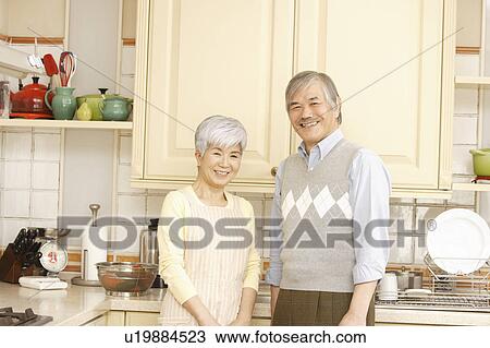 Senior couple standing in kitchen View Large Photo Image Stock Image - Senior couple standing in kitchen. Fotosearch