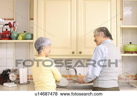 Stock Photo - Senior couple standing in kitchen. Fotosearch
