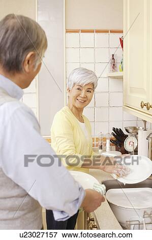 Stock Photo - Senior couple standing in kitchen. Fotosearch