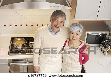 Senior couple standing in kitchen View Large Photo Image Stock Photograph - Senior couple standing in kitchen. Fotosearch