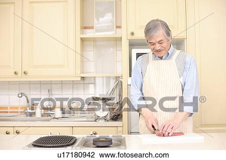 Stock Image - Senior man cooking. Fotosearch