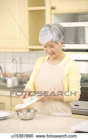 Stock Image - Senior woman cooking. Fotosearch