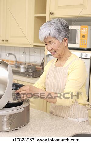 Stock Photo - Senior woman cooking. Fotosearch
