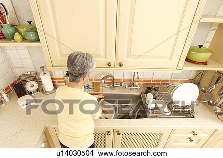 Picture - Senior woman standing in kitchen. Fotosearch