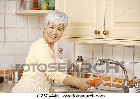 Senior woman standing in kitchen View Large Photo Image Stock Image - Senior woman standing in kitchen. Fotosearch