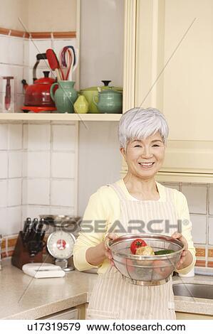 Senior woman standing in kitchen View Large Photo Image Stock Photo - Senior woman standing in kitchen. Fotosearch