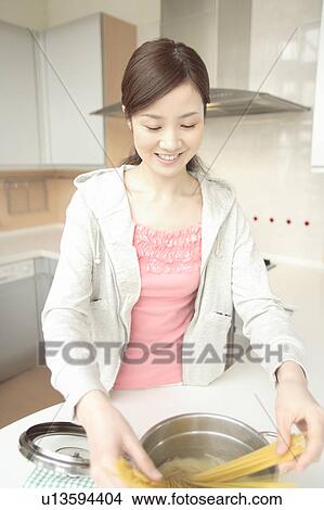 Young woman cooking in kitchen View Large Photo Image Picture - Young woman cooking in kitchen. Fotosearch