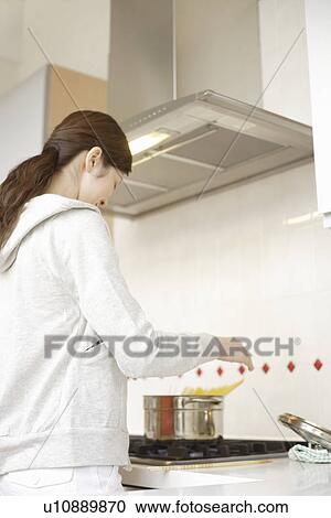 Young woman cooking in kitchen View Large Photo Image Stock Image - Young woman cooking in kitchen. Fotosearch
