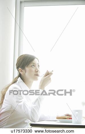 Young woman eating breakfast View Large Photo Image Stock Image - Young woman eating breakfast. Fotosearch