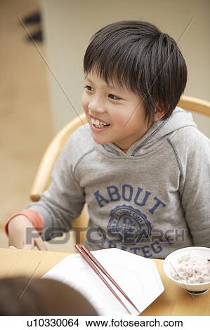 Boy eating at table View Large Photo Image Picture - Boy eating at table. Fotosearch