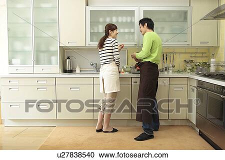 Stock Image - Couple cooking in kitchen. Fotosearch