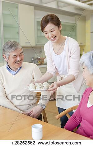 Daughter serving rice ball plate to parents View Large Photo Image Stock Image - Daughter serving rice ball plate to parents. Fotosearch