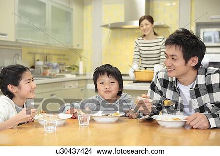Picture - Father and children eating curry and rice. Fotosearch