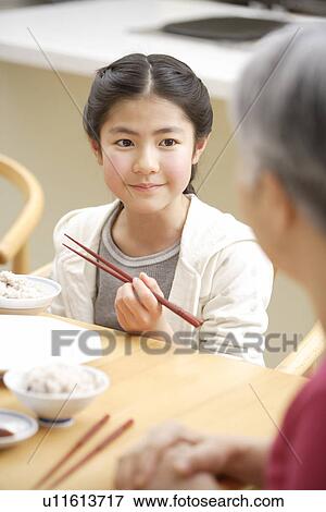 Stock Photo - Girl eating at table. Fotosearch