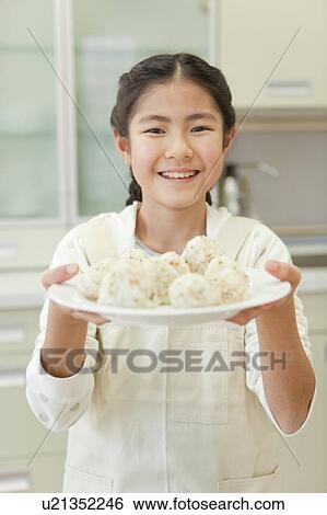 Girl holding plate of rice ball View Large Photo Image Stock Photograph - Girl holding plate of rice ball. Fotosearch