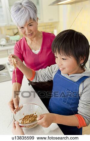 Grandson cooking with grandmother View Large Photo Image Stock Photo - Grandson cooking with grandmother. Fotosearch