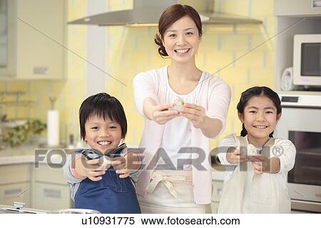 Stock Photography - Mother and children holding rice ball. Fotosearch