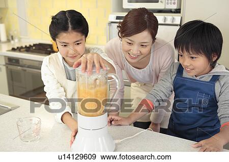 Stock Photo - Mother and children making fresh juice. Fotosearch