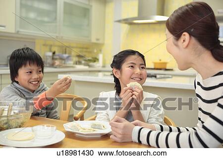 Stock Image - Mother and children making pot-sticker. Fotosearch