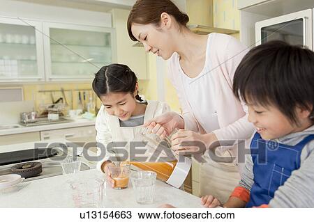Mother and children pouring fresh juice View Large Photo Image Stock Image - Mother and children pouring fresh juice. Fotosearch