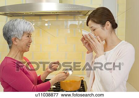 Stock Photo - Mother and daughter cooking. Fotosearch