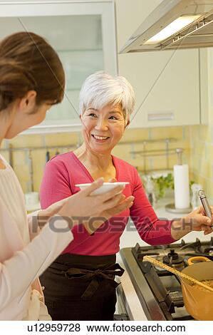 Stock Photo - Mother and daughter cooking. Fotosearch
