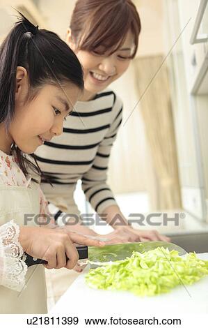 Stock Photo - Mother and daughter cooking. Fotosearch