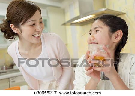 Mother and daughter drinking fresh juice View Large Photo Image Stock Photo - Mother and daughter drinking fresh juice. Fotosearch