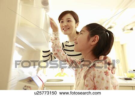 Stock Image - Mother and daughter looking refrigerator. Fotosearch