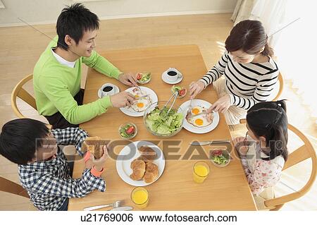 Stock Photograph - Parents and children having breakfast. Fotosearch