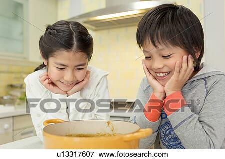Two children looking into pot View Large Photo Image Stock Photo - Two children looking into pot. Fotosearch