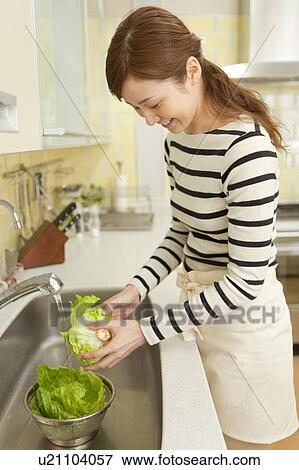 Young woman cooking in kitchen View Large Photo Image Stock Photo - Young woman cooking in kitchen. Fotosearch