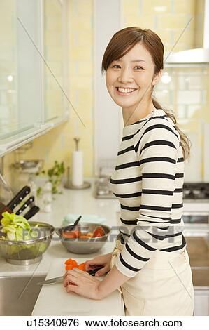 Young woman cooking in kitchen View Large Photo Image Stock Photograph - Young woman cooking in kitchen. Fotosearch