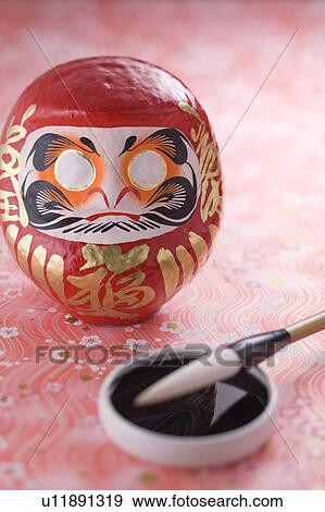 Stock Photo - Daruma doll and calligraphy brush. Fotosearch