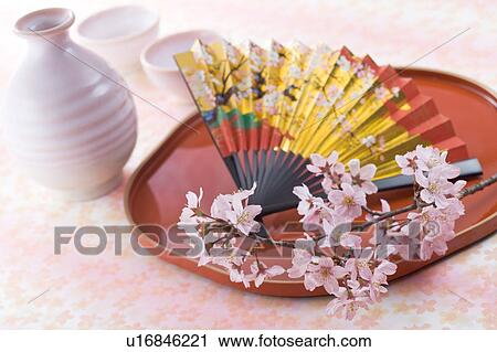 Stock Image - Sake bottle and cherry blossoms. Fotosearch