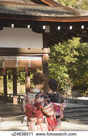 Stock Image - Two young women at shrine. Fotosearch
