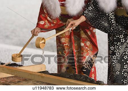 Stock Image - Women washing hand at Shinto shrine. Fotosearch