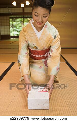 Stock Photo - Young woman in kimono greeting. Fotosearch
