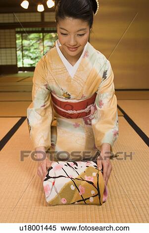 Stock Photography - Young woman in kimono greeting. Fotosearch