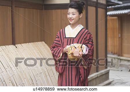 Young woman in kimono holding wrapped gift View Large Photo Image Stock Photo - Young woman in kimono holding wrapped gift. Fotosearch