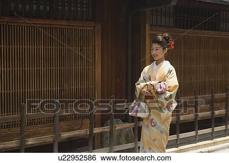 Young woman in kimono holding wrapped gift View Large Photo Image Stock Photograph - Young woman in kimono holding wrapped gift. Fotosearch