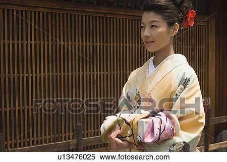 Young woman in kimono holding wrapped gift View Large Photo Image Stock Photography - Young woman in kimono holding wrapped gift. Fotosearch