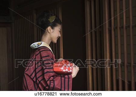 Young woman in kimono opening door View Large Photo Image Stock Image - Young woman in kimono opening door. Fotosearch