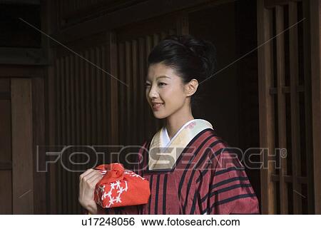 Young woman in kimono opening door View Large Photo Image Stock Photograph - Young woman in kimono opening door. Fotosearch